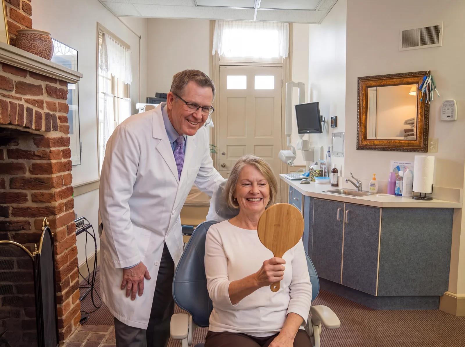 Dr. Steven Haywood with a patient seeing a new smile in a hand mirror