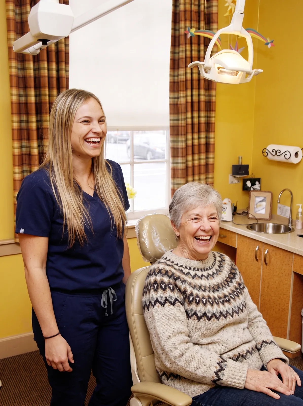 Madi, our dental assistant, sharing a laugh with a patient in a treatment room