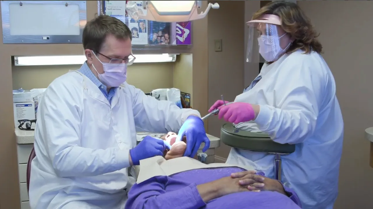 Dr. Steven Haywood treating a patient with an assistant